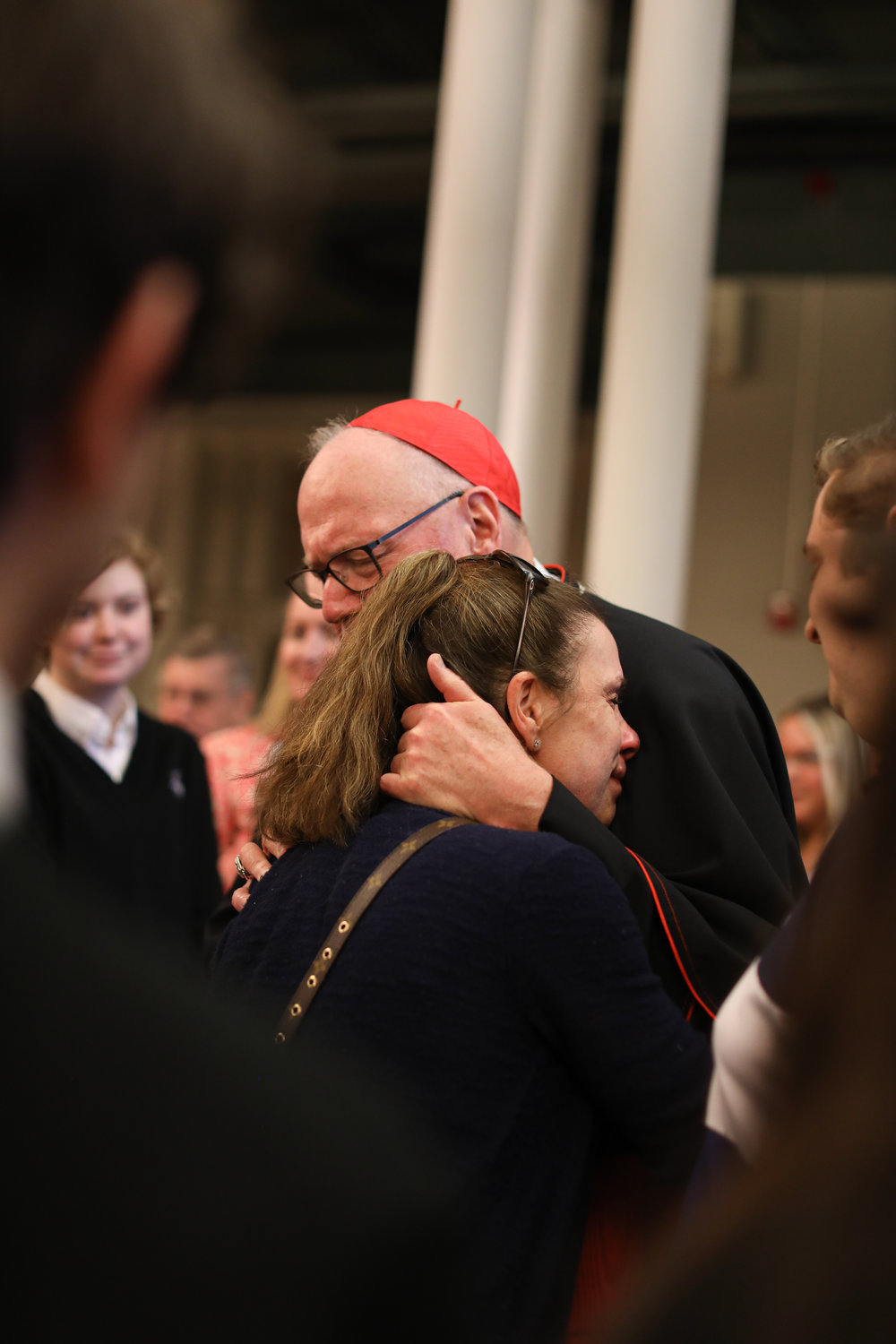 Cardinal Dolan embraces Jennifer Salomons.